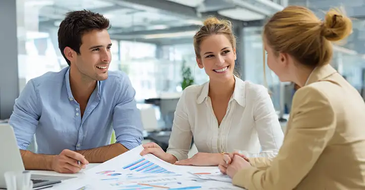 Drei Personen im Gespräch über Wohnungsverkauf